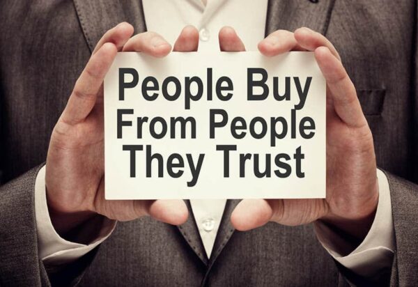 People Buy From People They Trust. Businessman holding a card with a message text written on it