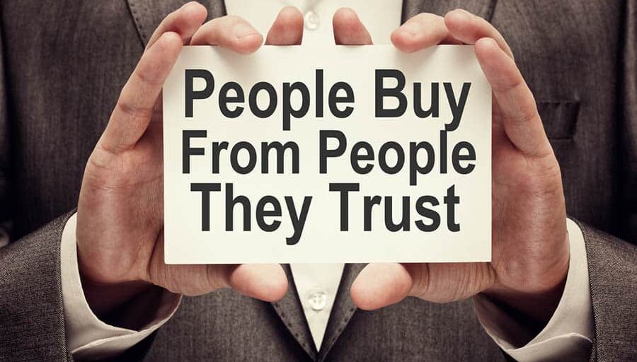 People Buy From People They Trust People Buy From People They Trust. Businessman holding a card with a message text written on it