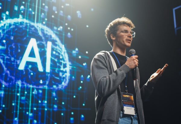 AI Startup Founder Talking About Innovations in the World of Artificial Intelligence and Large Language Models. Young Caucasian Man Talking About Future Technology Insights on Stage at a Global Event